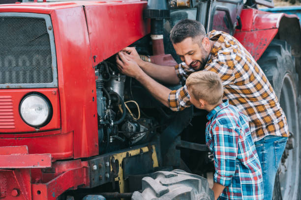 happy father and son repairing tractor engine together - boyhood imagens e fotografias de stock