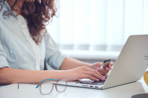 Hands holding credit card and using laptop. Online shopping stock photo