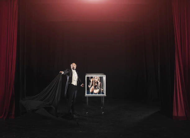 Magician assistant appearing inside cage Magician trick performance on stage