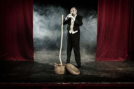 Magician doing snake charmer trick with rope