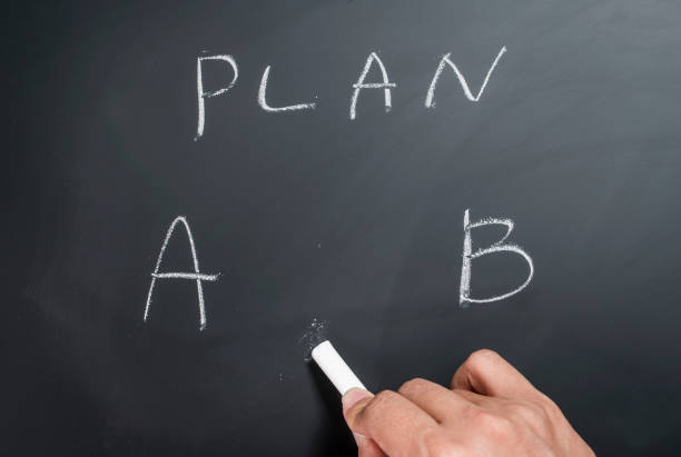istock plan letters on chalkboard. man hand write and choose plan on black board. 1007194146