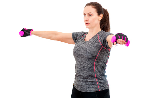Working out and staying in good health at any age concept with happy mature woman exercising her shoulders by doing lateral shoulder raise exercise isolated on white background with a clipping path