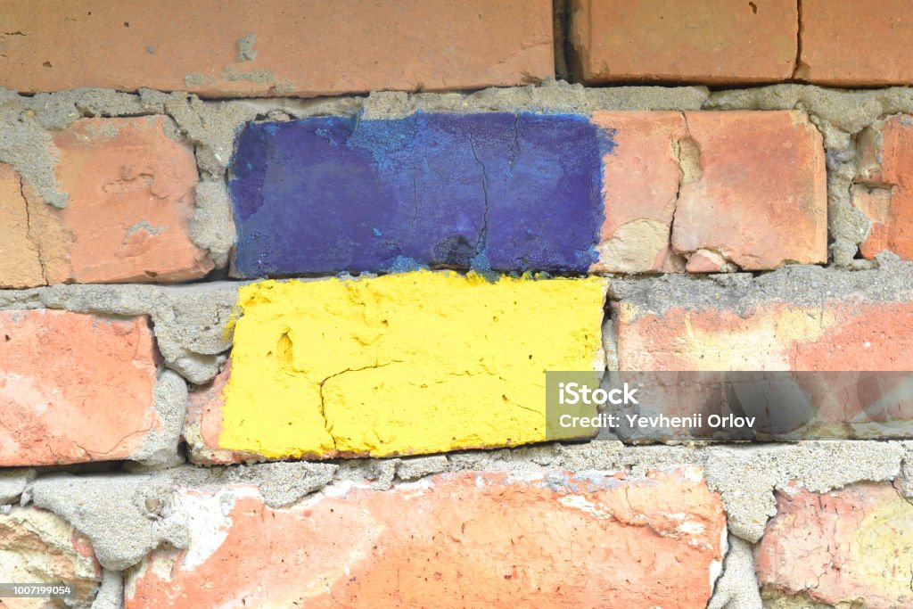 Flag of Ukraine on a brick wall. Abstract Stock Photo