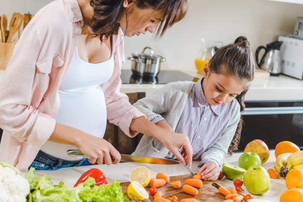 istock mother with daughter slicing carrots 1007199868