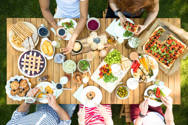 istock Top view on people eating lunch at garden table during party 1007202738