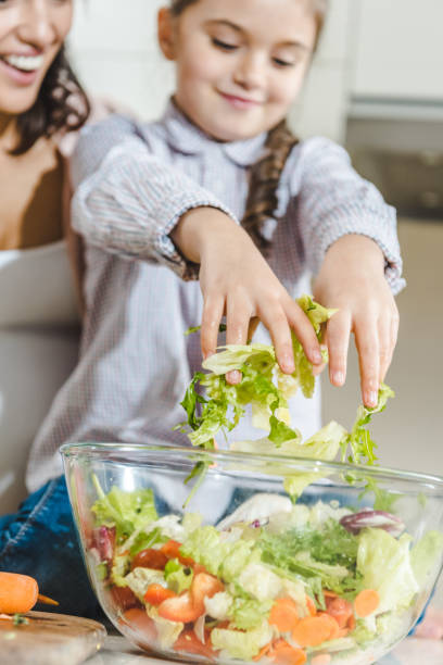 istock mother with daughter making salad 1007203344