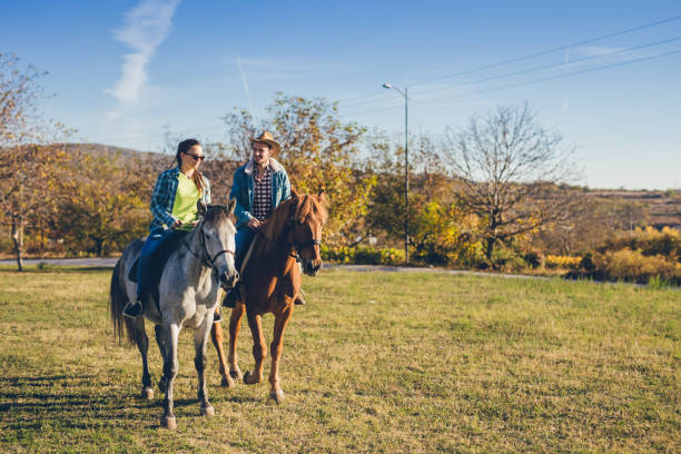 istock Couple riding horses at sunset 1007210428