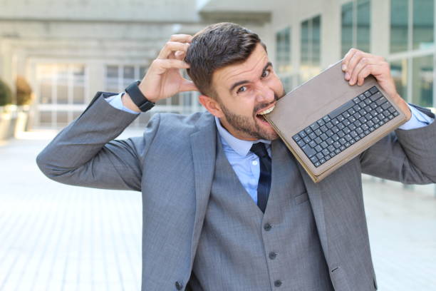 istock Angry employee biting laptop in office space 1007214344