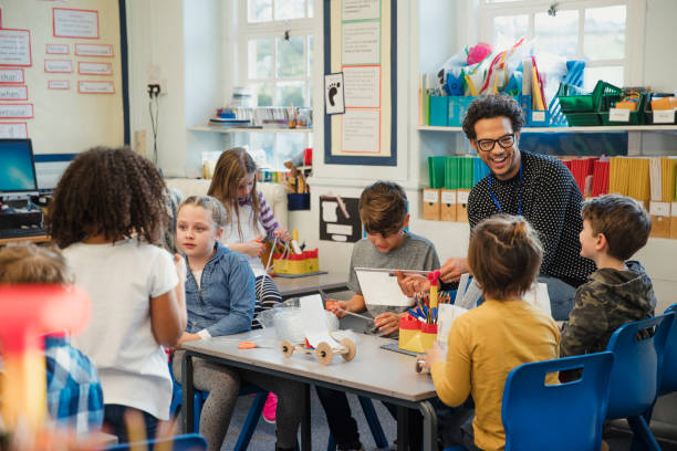 Building in Elementary Class with their Teacher Elementary school children build 3d models using recycled materials with their teacher during class. This is a school in Hexham, Northumberland in north eastern England. instructor stock pictures, royalty-free photos & images