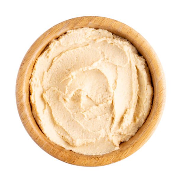 istock Classic chickpea hummus in wooden bowl isolated on white. Top view. 1007215314