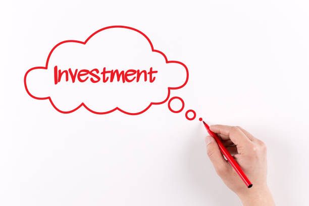 istock Hand writing Investment on white paper, View from above 1007225796