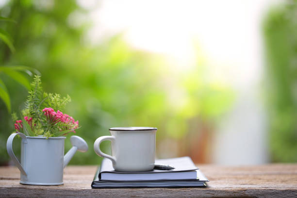 istock Pink flower in white pot and brown cup with notebook diary 1007227286