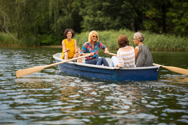 istock Woman rowing boat in lake while friends talking 1007231352