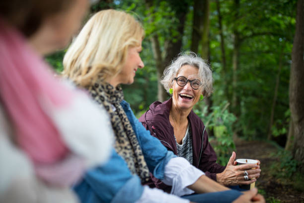 mulher rindo enquanto olha para os amigos na floresta - three people adults germany berlin germany - fotografias e filmes do acervo