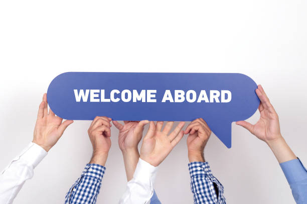 group of people holding the welcome aboard written speech bubble - new greetings imagens e fotografias de stock