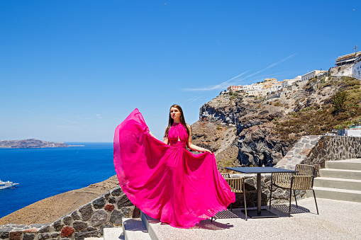 Young woman in red dress on Santorini island, Greece