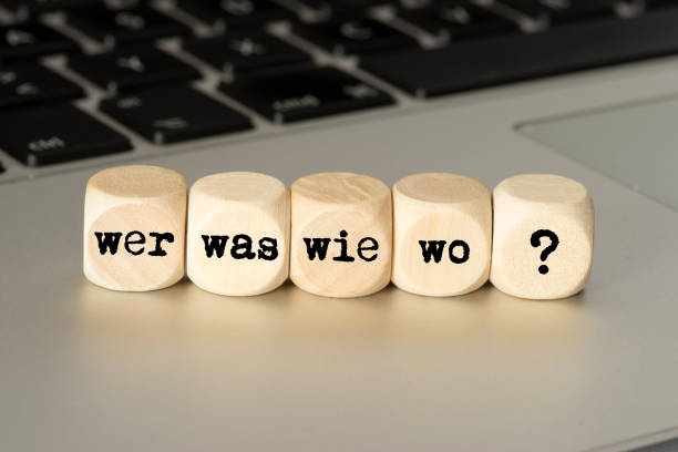A computer and dice with the questions, WHO, What, How, Where