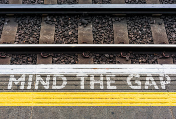 mind the gap знак на платформе станции лондонского метро - go английское слово стоковые фото и изображения