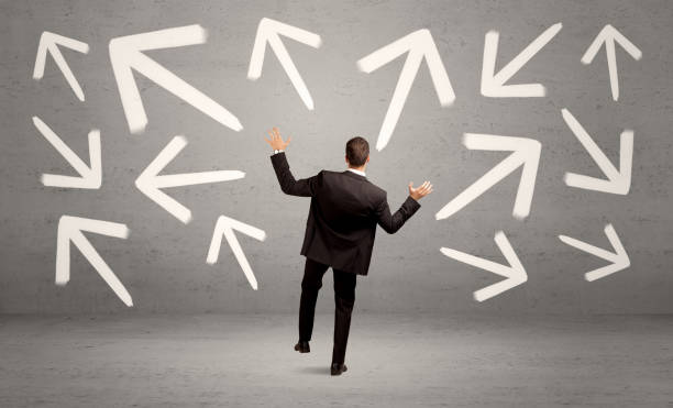 istock Confused salesman with arrows on wall 1007254906
