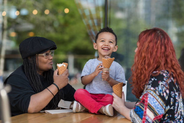 istock Two moms eat ice cream with their three-year old son 1007261944