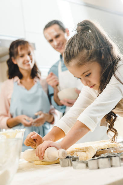 istock parents watching how serious little daughter rolling out dough at kitchen 1007262190