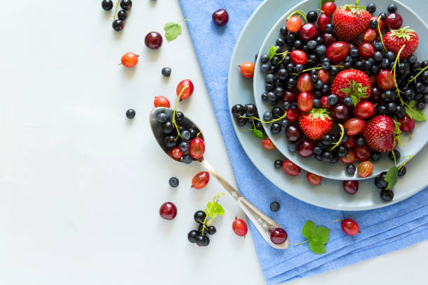 fruit salad with strawberry, blueberry, cherry, gooseberry and black currant on wooden gray background. flat lay. top view - berry fruit currant variation gooseberry imagens e fotografias de stock