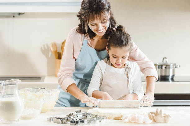 istock mother with daughter rolls out dough 1007262490