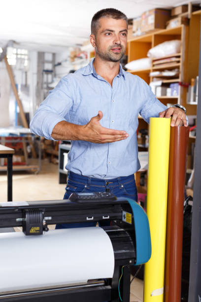 istock male printing worker with rolls of colored paper 1007270442