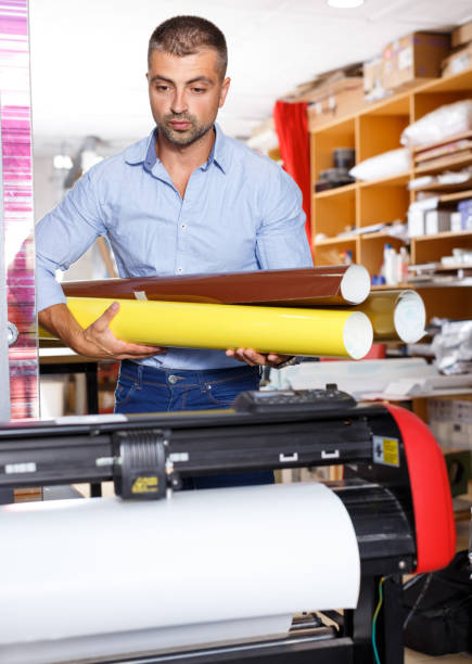 istock male printing worker with rolls of colored paper 1007270700