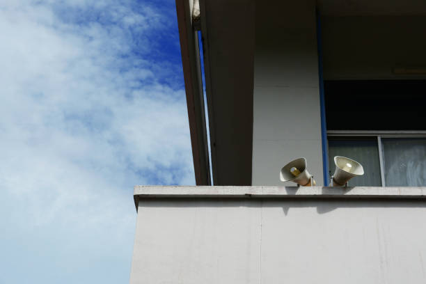 deux haut-parleurs sur le bord des bâtiments mur et bleu ciel avec nuages blancs - at the edge of audio photos et images de collection