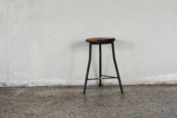 istock three iron leg's chair on dirty cement ground with old white wall 1007277812