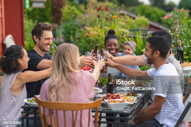 A Group Of Young Adult Friends Dining Al Fresco On A Patio Stock Photo - Download Image Now