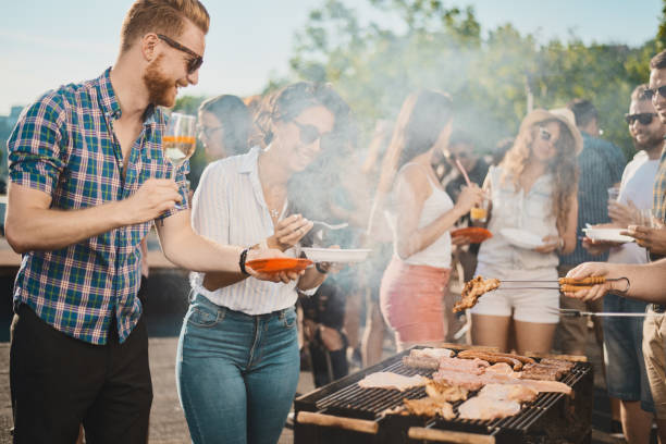 istock Group of people standing around grill. 1007278842