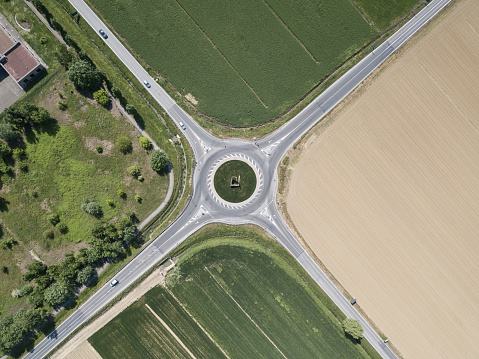 aerial view of four roads with roundabout surrounded with agro fields, Italy