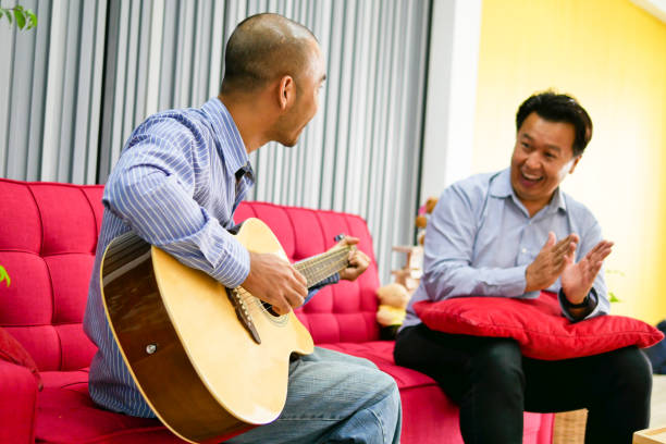 istock Two Asian guys are playing guitar, music instrument 1007287080
