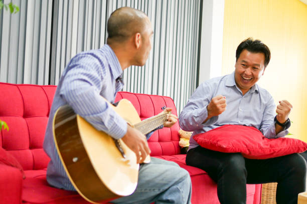 istock Two Asian guys are playing guitar, music instrument 1007287144