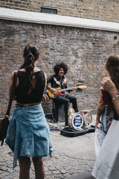 London, UK - July 22, 2018: Street performer singing on Brick Lane, London. The street is the heart of the London's Bangladeshi-Sylheti community and is famous for its many curry houses.