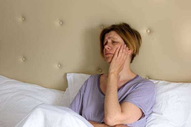 istock The woman feels sick, sitting in bed. Headache. Toothache. 1007294092