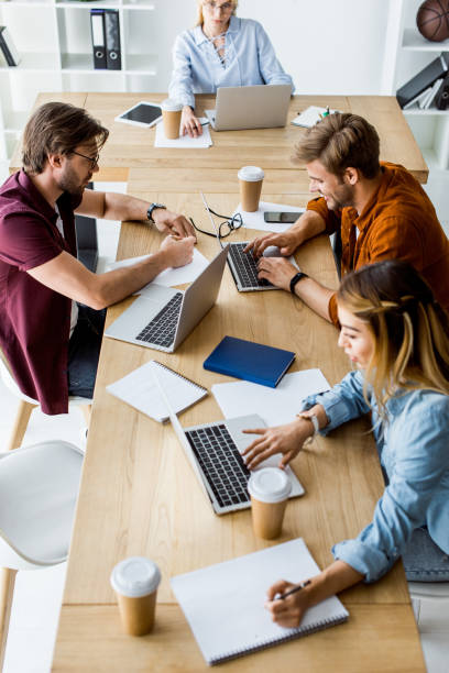 istock high angle view of young multicultural colleagues working on startup project in office with gadgets 1007294122
