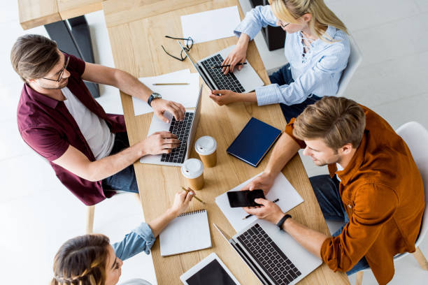 istock high angle view of colleagues working on startup project in office and using gadgets 1007294164