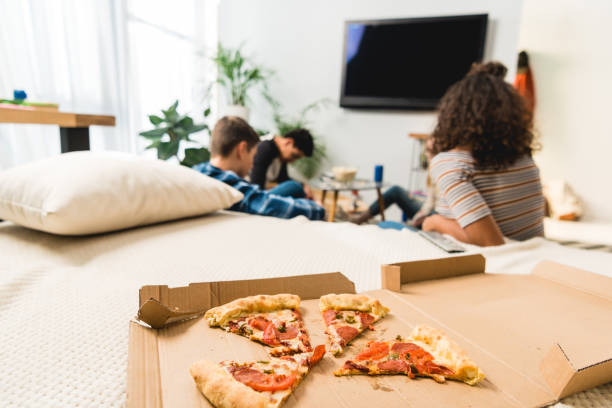 istock friends watching tv with pizza on foreground 1007294180