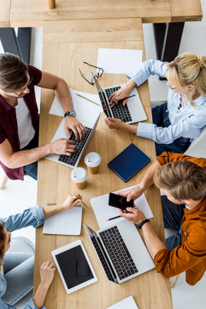 istock top view of colleagues working on startup project in office and using gadgets 1007294308