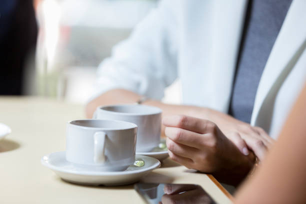 istock Two unrecognizable people enjoy hot tea together 1007304186