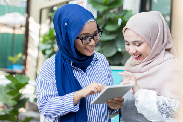 istock Two businesswomen work on digital tablet together 1007304250