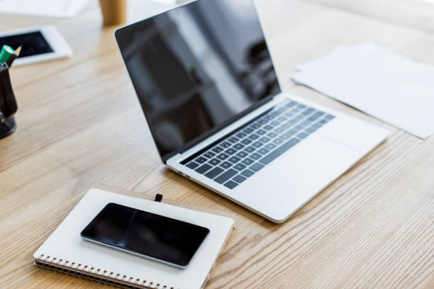 istock laptop, smartphone and notebook on table in business office 1007305058