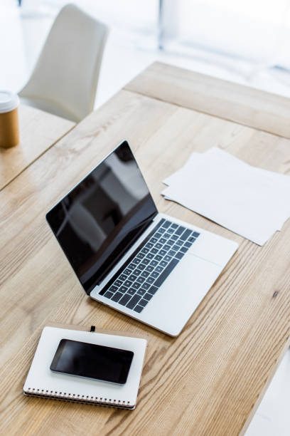 istock high angle view of laptop, smartphone and notebook on table in business office 1007305062
