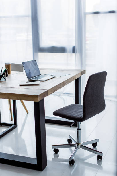 istock laptop ans disposable coffee cup on table in business office 1007305112