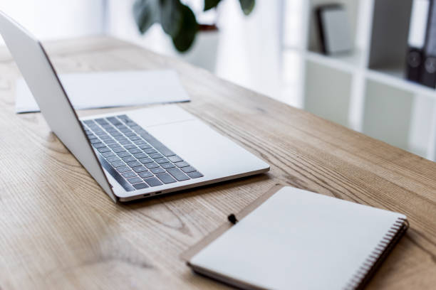 istock laptop and notebook on wooden table in business office 1007305134