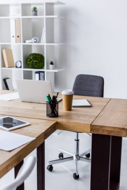 istock laptop and disposable coffee cup on table in business office 1007305138