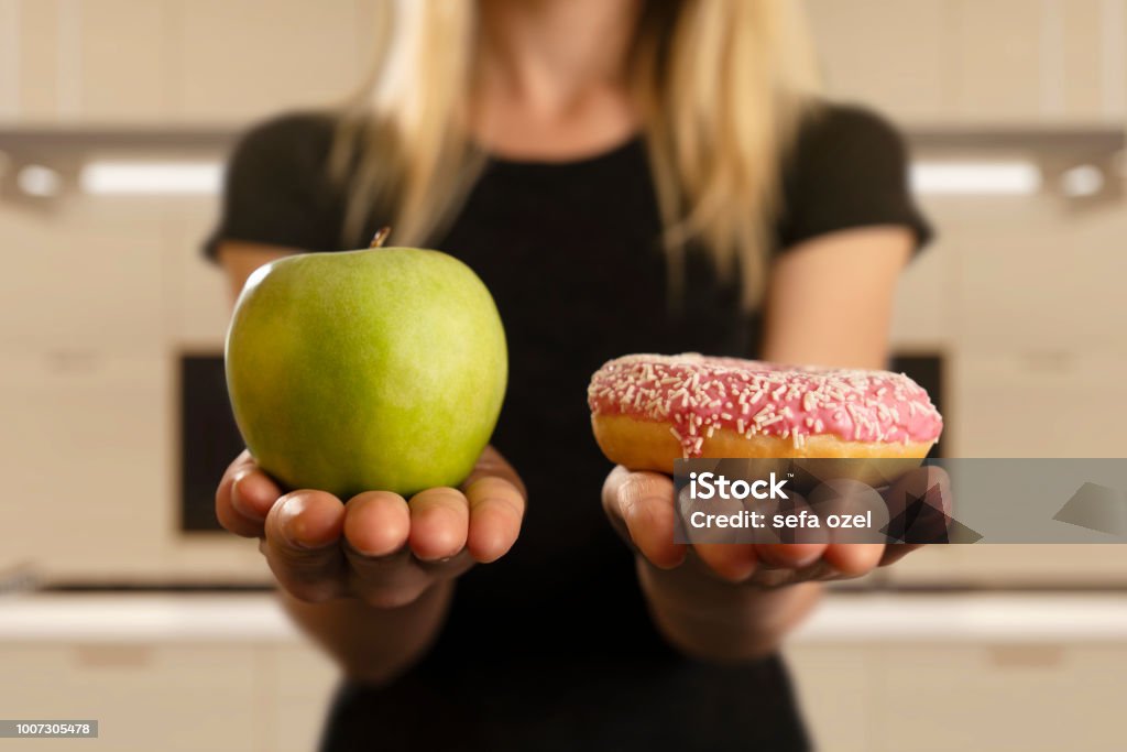 Choosing Between Donut And Apple Dieting, Choice, Fruit, Donut, Women Healthy Eating Stock Photo